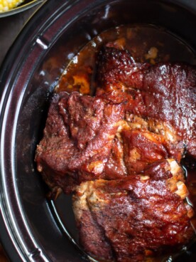 ribs in the slow cooker, cooked with barbecue sauce on top.