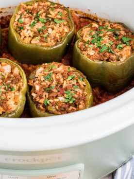 beef stuffed peppers in a white slow cooker.