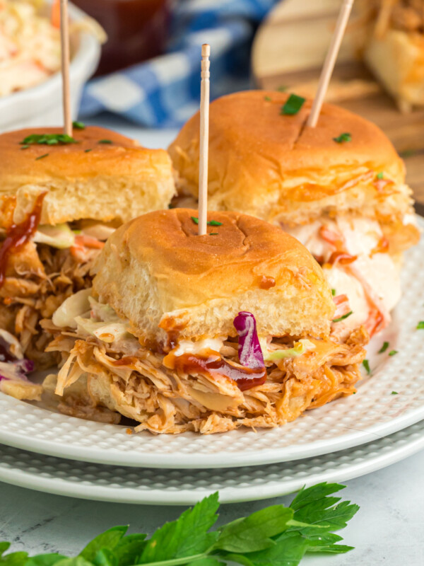 slow cooker bbq chicken sliders on two plates.